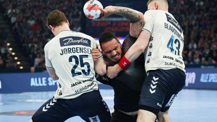Rogerio Moraes (M) wird von den Flensburgern Lukas Jörgensen (l) und Blaz Blagotinsek am Wurf gehindert. Rogerio Moraes (M) wird von den Flensburgern Lukas Jörgensen (l) und Blaz Blagotinsek am Wurf gehindert.