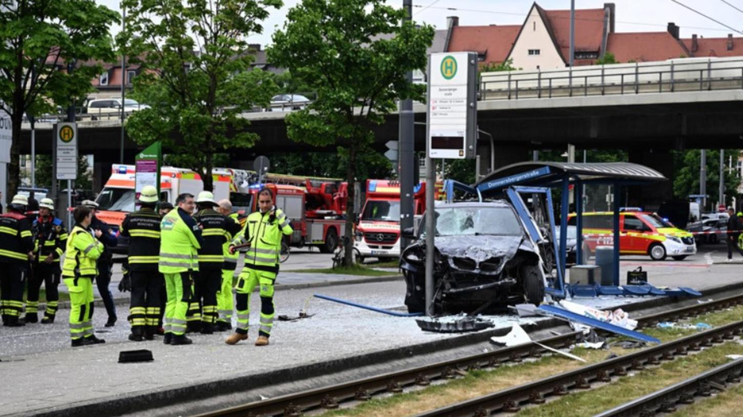 ARCHIV - 07.05.2025, Bayern, München: Einsatzkräfte stehen bei dem Unfallfahrzeug und einer zerstörten Haltestelle. Ein Auto fährt in der Münchner Innenstadt in eine Haltestelle. ARCHIV - 07.05.2025, Bayern, München: Einsatzkräfte stehen bei dem Unfallfahrzeug und einer zerstörten Haltestelle. Ein Auto fährt in der Münchner Innenstadt in eine Haltestelle.