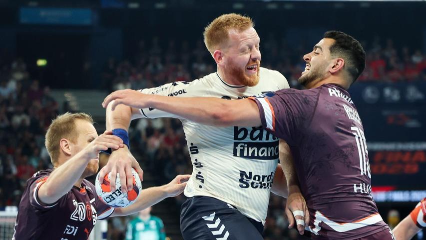 Flensburgs Jim Gottfridsson (M) wird von Montpelliers Stas Skube (l) und Ahmed Hesham am Wurf gehindert. Flensburgs Jim Gottfridsson (M) wird von Montpelliers Stas Skube (l) und Ahmed Hesham am Wurf gehindert.