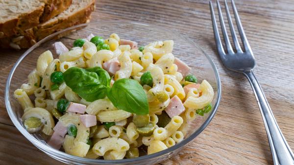 Pasta salad in a glass bowl on wood.. Pasta salad