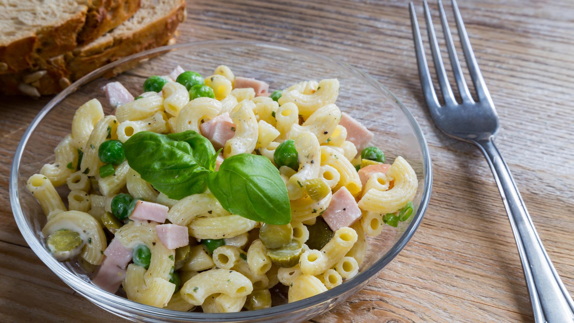 Pasta salad in a glass bowl on wood.. Pasta salad 