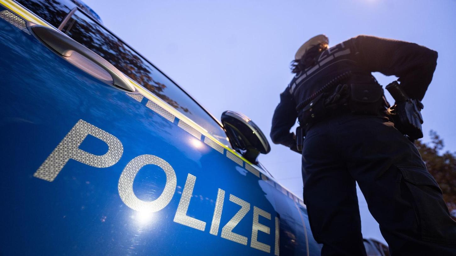 Eine Polizistin steht neben einem Polizeifahrzeug. (Symbolbild) Eine Polizistin steht neben einem Polizeifahrzeug. (Symbolbild)