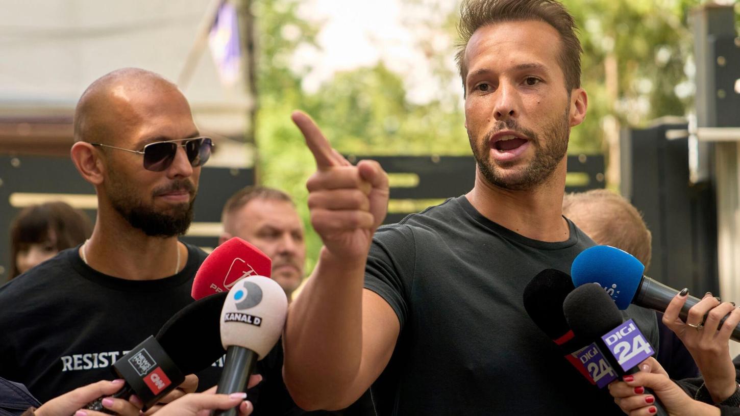 Andrew Tate (links) schaut zu seinem Bruder Tristan Tate, der am 21. Mai vor einer Polizeistation in Voluntari in Rumänien redete. Andrew Tate (links) schaut zu seinem Bruder Tristan Tate, der am 21. Mai vor einer Polizeistation in Voluntari in Rumänien redete.