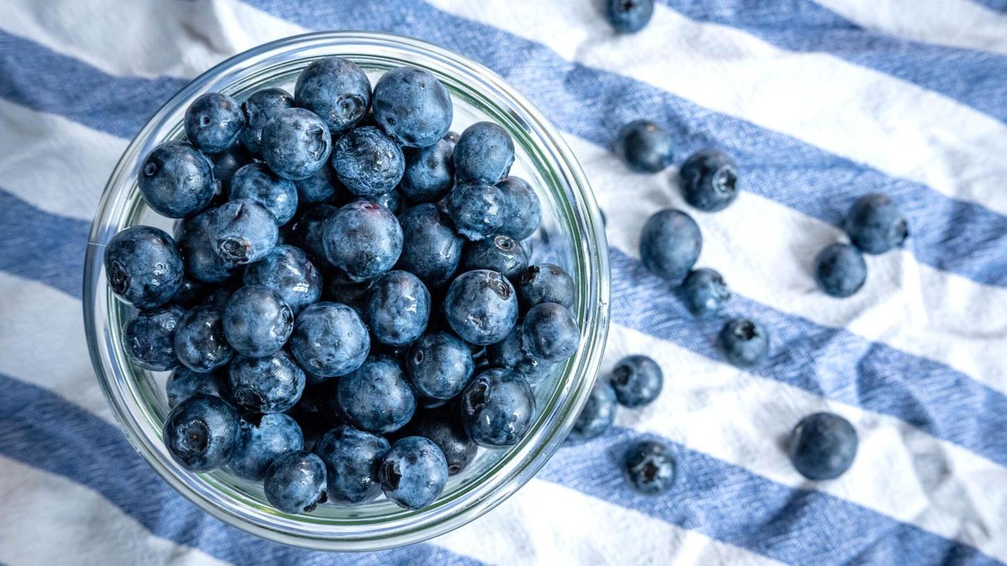 Beeren statt Chips oder Nüsschen: Heidelbeeren, auch Blaubeeren genannt, liegen auf einem Esstisch und werden gern gesnackt. Beeren statt Chips oder Nüsschen: Heidelbeeren, auch Blaubeeren genannt, liegen auf einem Esstisch und werden gern gesnackt.