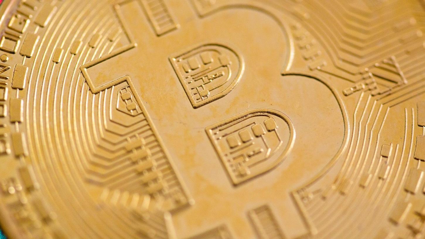 Eine Bitcoin-Münze liegt auf einem Tisch. (Symbolbild) Eine Bitcoin-Münze liegt auf einem Tisch. (Symbolbild)