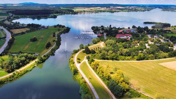 Der Altmühlsee gehört zu den schönsten Seen in Bayern. Neben Sonnenbaden und Schwimmen bietet er viele Möglichkeiten, etwas zu unternehmen. Ein 13 Kilometer langer Rad- und Wanderweg fasst den See ein. So können Sie das Gewässer und seine Umgebung in allen Facetten erkunden und sich den schönsten Strand aussuchen. Auch Wassersportfans kommen hier auf ihre Kosten. Surfer und Kiter finden am Altmühlsee ideale Bedingungen vor. Das Ausflugsschiff "MS Altmühlsee" verbindet die Freizeitzentren während der Sommersaison miteinander. Der Altmühlsee liegt nördlich von Gunzenhausen an der B466 bzw. der B13. Mit dem Auto sind Sie in gut einer Stunde von Nürnberg aus da.