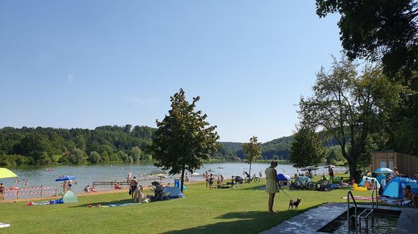 Der zweitkleinste See der fränkischen Seenplatte ist der Hahnenkammsee, dieser ist besonders familienfreundlich. Für die Kleinen gibt es im flachen Uferbereich einen extra abgetrennten Nichtschwimmerbereich. Auf dem langen Strand können Sie sich in der Sonne räkeln oder Sandburgen bauen. Wer nicht gerne auf Sand liegen möchte, kann die Liegewiesen nutzen. Die Bäume spenden hier angenehmen Schatten. Als Freizeitangebote stehen ein Tretboot- und Pedelec-Verleih, ein Beach-Volleyballfeld und Tischtennisplatten zur Verfügung. Von Nürnberg aus liegt der kleine See 90 Minuten entfernt. Die Adresse lautet: Am See, Hechlingen am See, im Landkreis Weißenburg-Gunzenhausen.