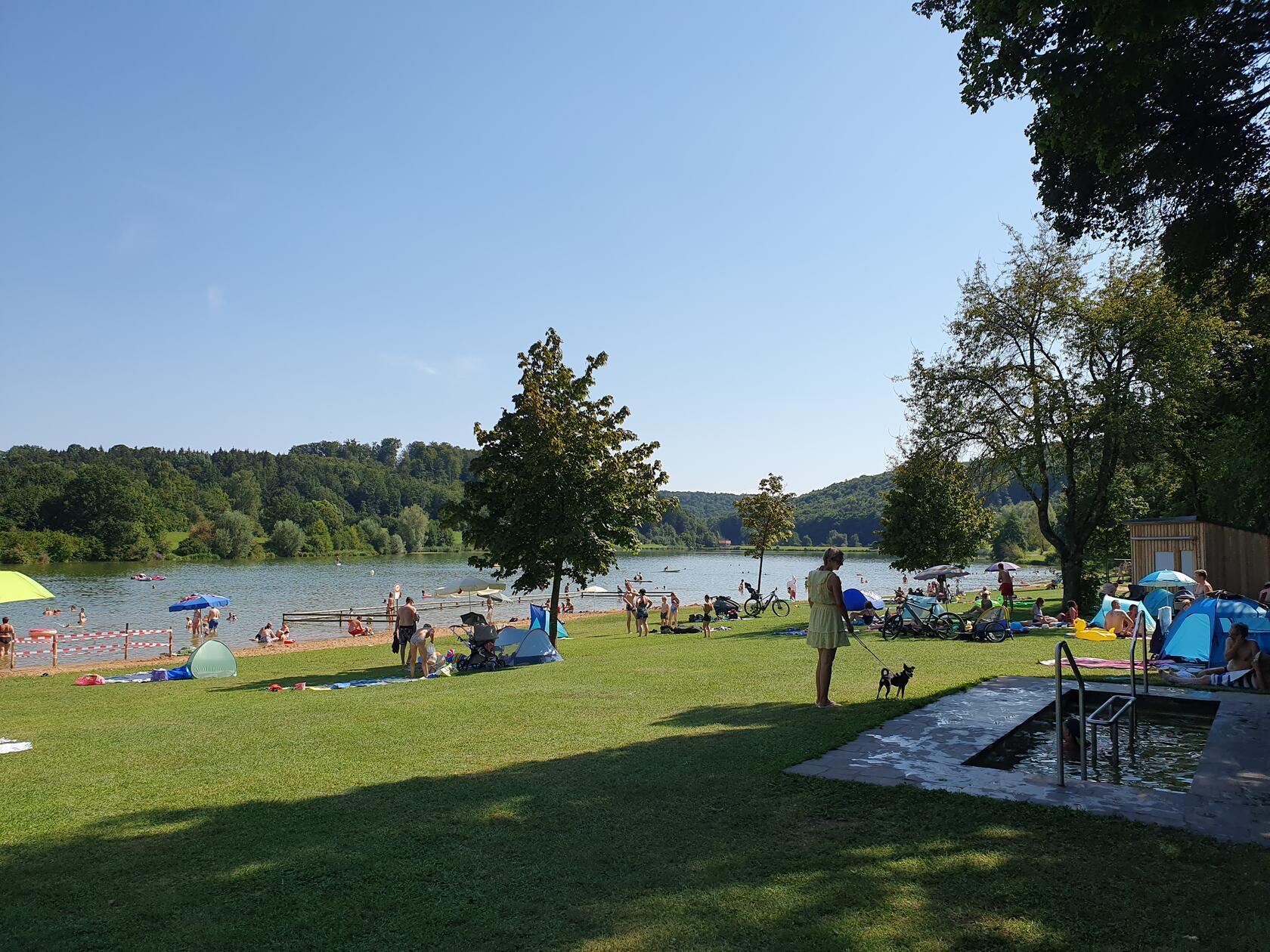 Der zweitkleinste See der fränkischen Seenplatte ist der <b>Hahnenkammsee</b>, dieser ist besonders familienfreundlich. Für die Kleinen gibt es im flachen Uferbereich einen extra abgetrennten Nichtschwimmerbereich. Auf dem langen Strand können Sie sich in der Sonne räkeln oder Sandburgen bauen. Wer nicht gerne auf Sand liegen möchte, kann die Liegewiesen nutzen. Die Bäume spenden hier angenehmen Schatten. Als Freizeitangebote stehen ein Tretboot- und Pedelec-Verleih, ein Beach-Volleyballfeld und Tischtennisplatten zur Verfügung. 
Von Nürnberg aus liegt der kleine See 90 Minuten entfernt. Die Adresse lautet: Am See, Hechlingen am See, im Landkreis Weißenburg-Gunzenhausen.