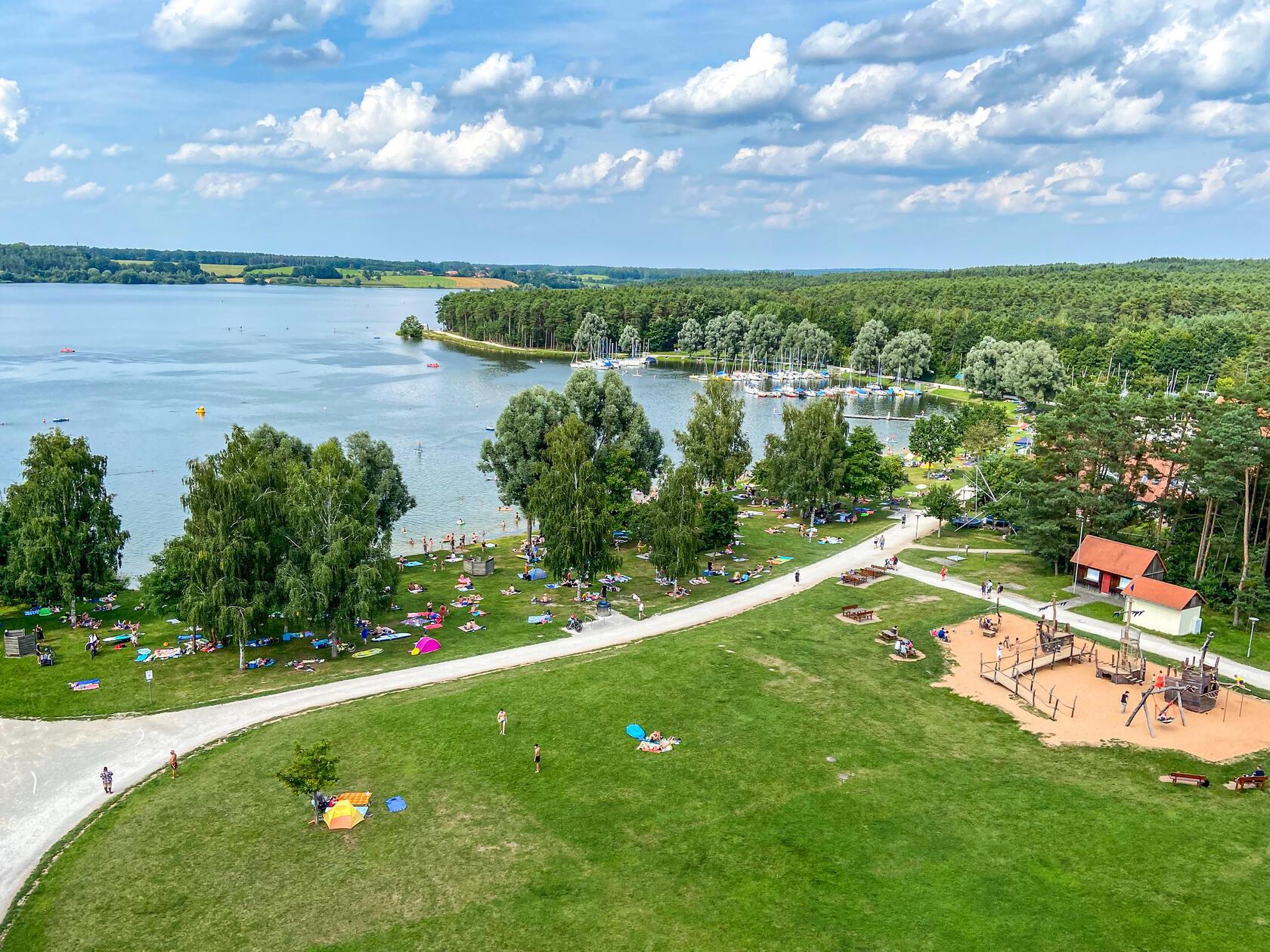 Der <b>Rothsee</b> - ein Ort, um die Seele baumeln zu lassen, ganz in der Nähe von Nürnberg. Wer sich nur ausruhen möchte, findet bestimmt ein sonniges oder auch schattiges Plätzchen auf der großen Liegewiese. Aber auch für sportlichere Aktivitäten ist hier gesorgt, falls Sie Lust auf Volleyball, Tretbootfahren und Minigolf haben.
Für das besondere Urlaubsfeeling sorgt hier der Sandstrand an manchen Stellen des Sees. Das Schöne ist, dass es hier auch für Ihre vierbeinigen Freunde einen Hundestrand gibt. Und für das leibliche Wohl sorgen die Strandhaus-Cafés auf den beiden Uferseiten. 
Die Anreise ist mit dem Auto ganz einfach über die A73 und die A9 bis zur Ausfahrt Allersberg. Vor Ort gibt es sogar mehrere Parkplätze.