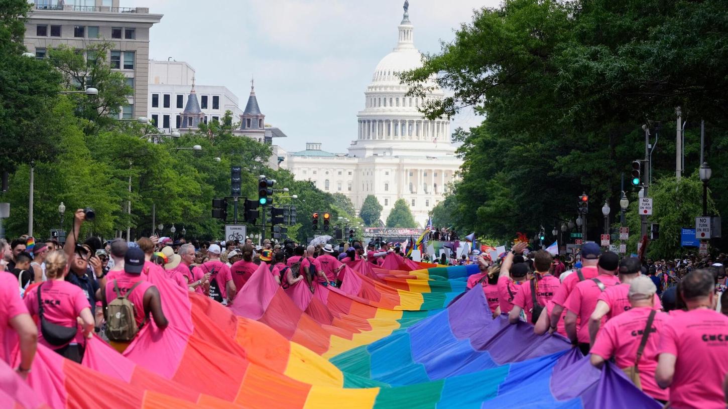 Mit riesigen Regenbogenfahnen demonstrieren Menschen mit Blick auf das US-Kapitol bei einer Pride-Parade in Washington für die Rechte der LGBTQI+-Gemeinschaft. Mit riesigen Regenbogenfahnen demonstrieren Menschen mit Blick auf das US-Kapitol bei einer Pride-Parade in Washington für die Rechte der LGBTQI+-Gemeinschaft.
