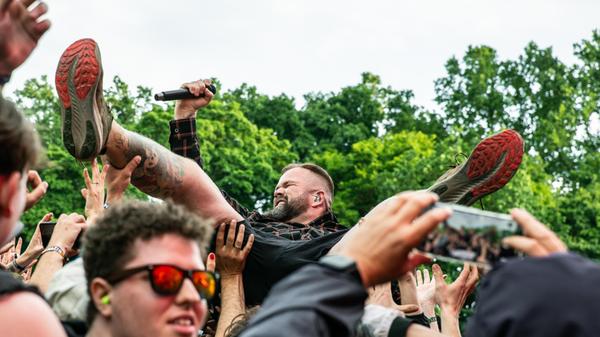 Bei Feine Sahne Fischfilet ist die Hölle los vor der Mandora Stage. Sänger Monchi badet in der Menge.