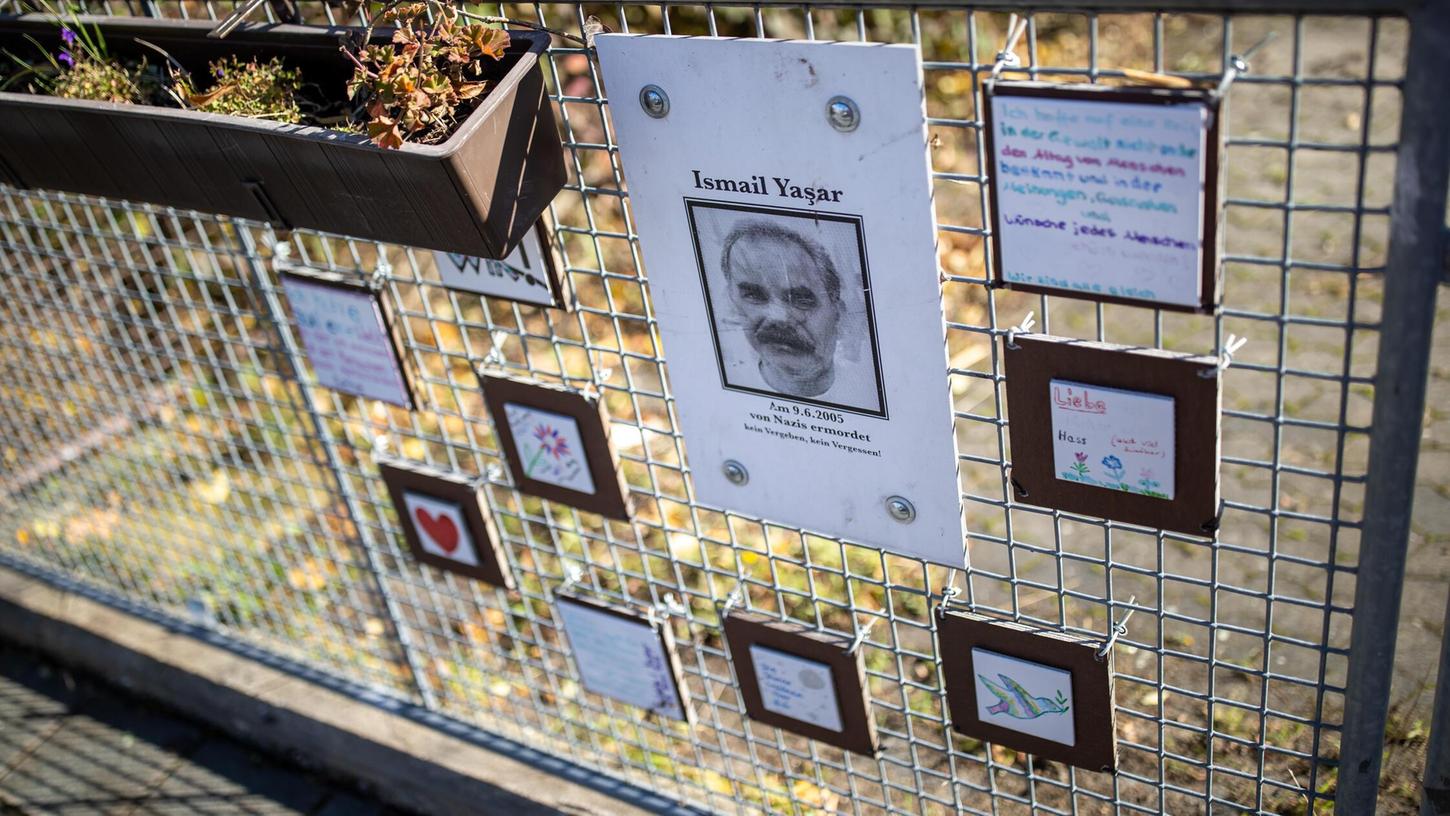 Eine Holztafel mit dem Abbild des vom NSU ermordeten İsmail Yaşar hängt am Tatort an einem Zaun. Eine Holztafel mit dem Abbild des vom NSU ermordeten İsmail Yaşar hängt am Tatort an einem Zaun.
