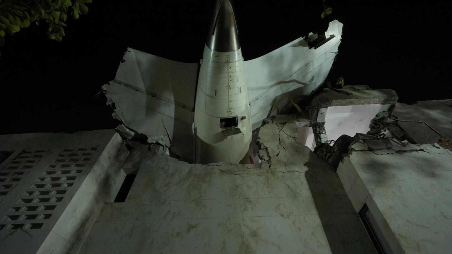 Das Heck des Flugzeugs steckt in einem Gebäude an der Absturzstelle in der nordwestindischen Stadt Ahmedabad im Bundesstaat Gujarat. (Foto aktuell) Das Heck des Flugzeugs steckt in einem Gebäude an der Absturzstelle in der nordwestindischen Stadt Ahmedabad im Bundesstaat Gujarat. (Foto aktuell)