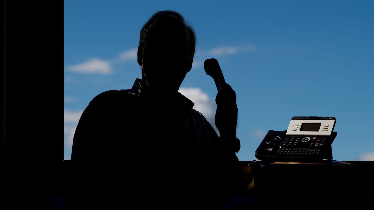 Ein Mann mit Telefonhörer in der Hand. (Symbolbild) Ein Mann mit Telefonhörer in der Hand. (Symbolbild)