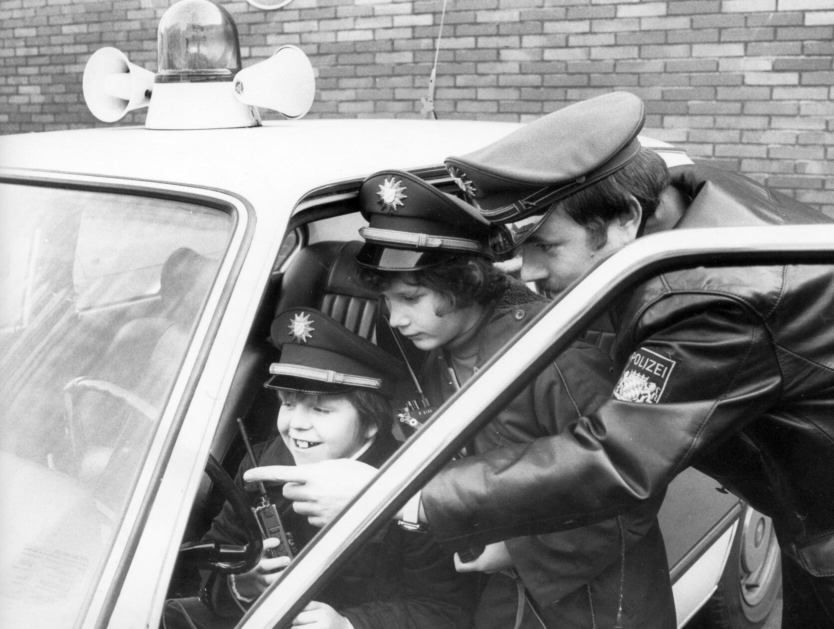 Kleine Helden im Einsatz: Im Jahr 1978 halfen die beiden 11-jährigen Freunde Michael Heller (links) und Stefan Schuster (Mitte) einen tödlichen Verkehrsunfall mit Fahrerflucht aufzuklären. Die Polizei hatte die Bevölkerung über Bayern 3 um Hinweise nach dem flüchtigen Mercedes-Fahrer gebeten. Auf dem Weg zum Spielplatz entdeckten die beiden aufmerksamen Spürnasen einen beschädigten Mercedes. Sofort prägten sie sich das Kfz-Kennzeichen ein und benachrichtigten die Polizei, woraufhin der Unfallverursacher gefasst werden konnte. Als Dankeschön durften die beiden einen aufregenden Tag bei der Polizei verbringen.
