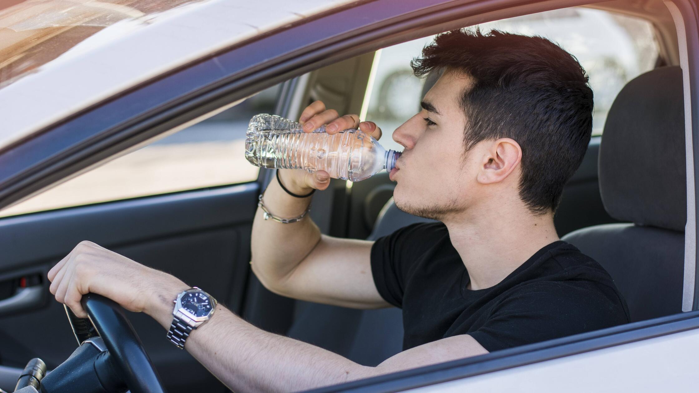 Hübscher junger Mann oder Teenager, der Auto fährt