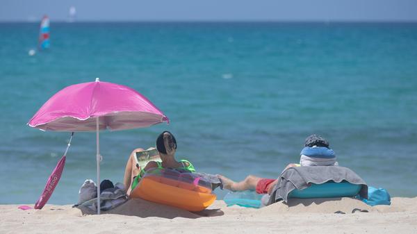 ARCHIV - 07.06.2025, Spanien, Palma: Menschen sonn