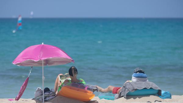 ARCHIV - 07.06.2025, Spanien, Palma: Menschen sonn