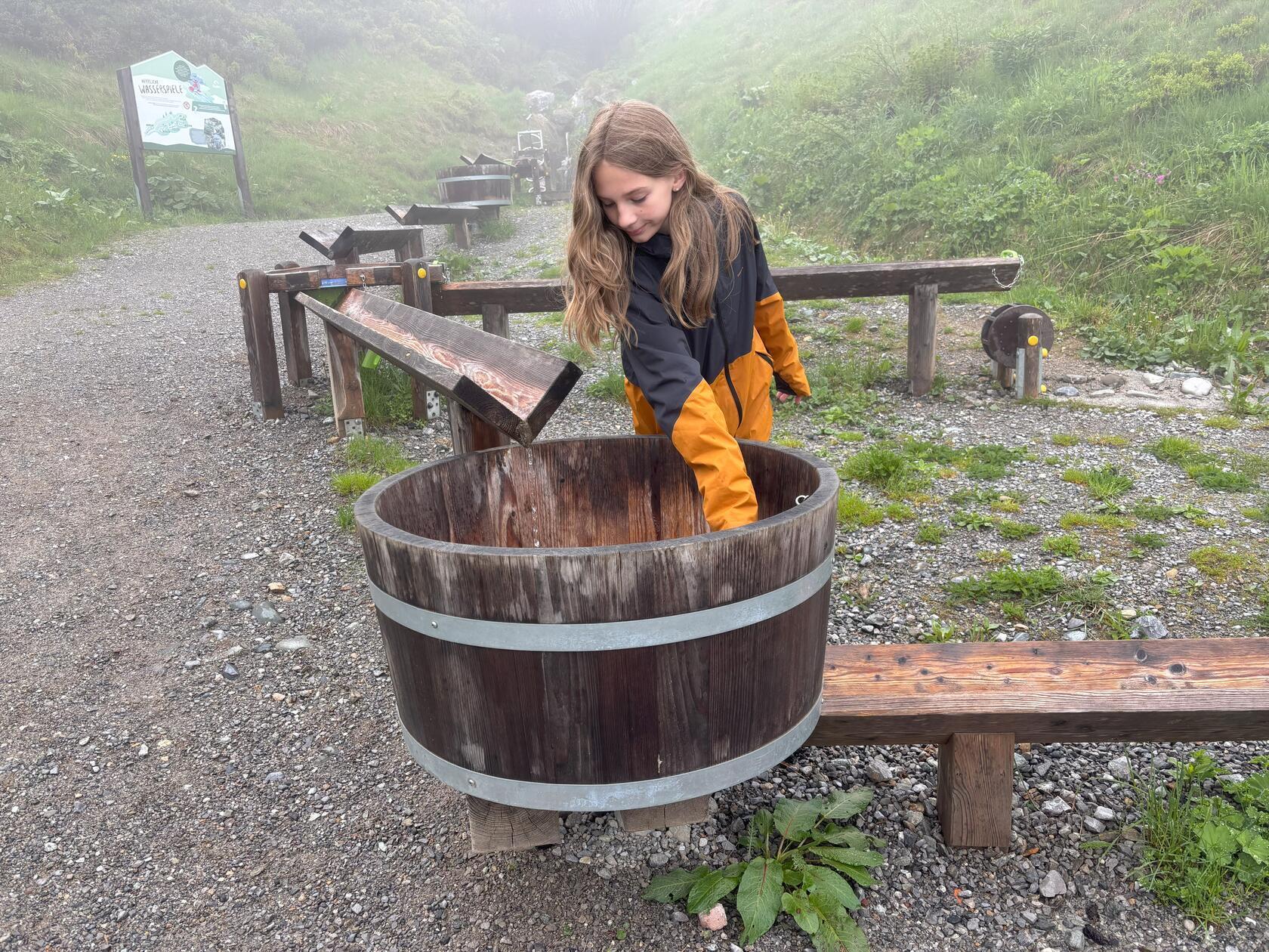 Golmi's Forschungspfad macht es möglich - ein 2,4 km langer, abwärts verlaufender Wanderweg mit einem Aktivprogramm für Familien. 22 Erlebnisstationen laden dazu ein, die Natur bewusst zu erleben, zu forschen und die alpine Tier- und Pflanzenwelt des Montafons zu entdecken. An manchen kann man aber auch einfach plantschen - wie Nele hier am Wasserbottich.