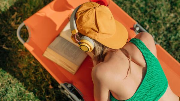 Person relaxing on a sun lounger in the backyard,
