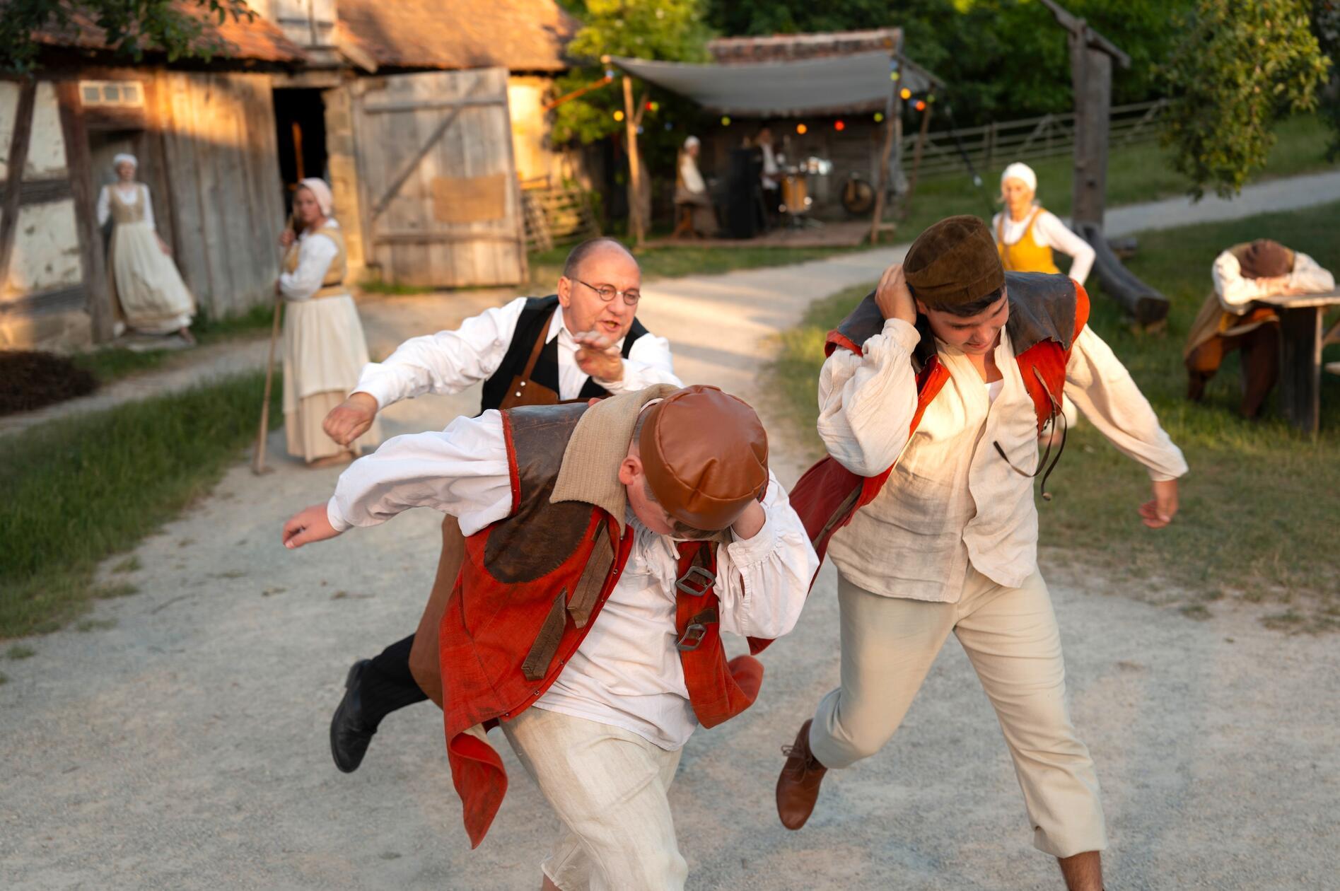 Metzger Georg (Johannes Szilvássy) führt die schuldigen Lausbuben Franz (Hannes Ackermann) und Albrecht (Tim Ackermann) vor.