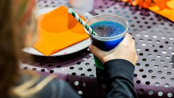 Kind trinkt ein Slush-Eis bei einem Kindergeburtst