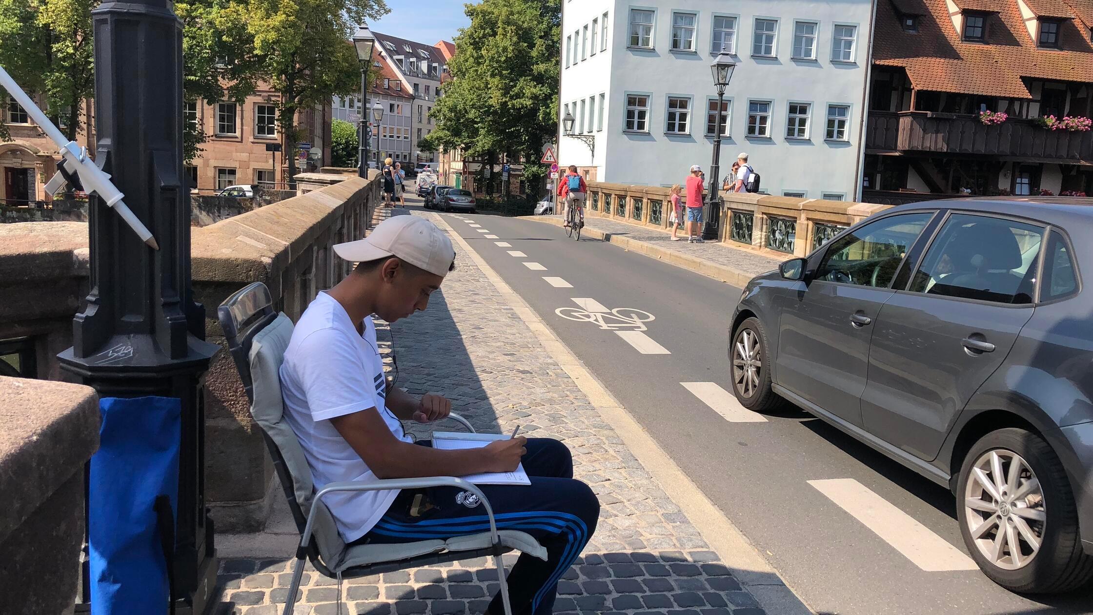 Leute in Campingstühlen am Straßenrand in Nürnberg - das steckt dahinter