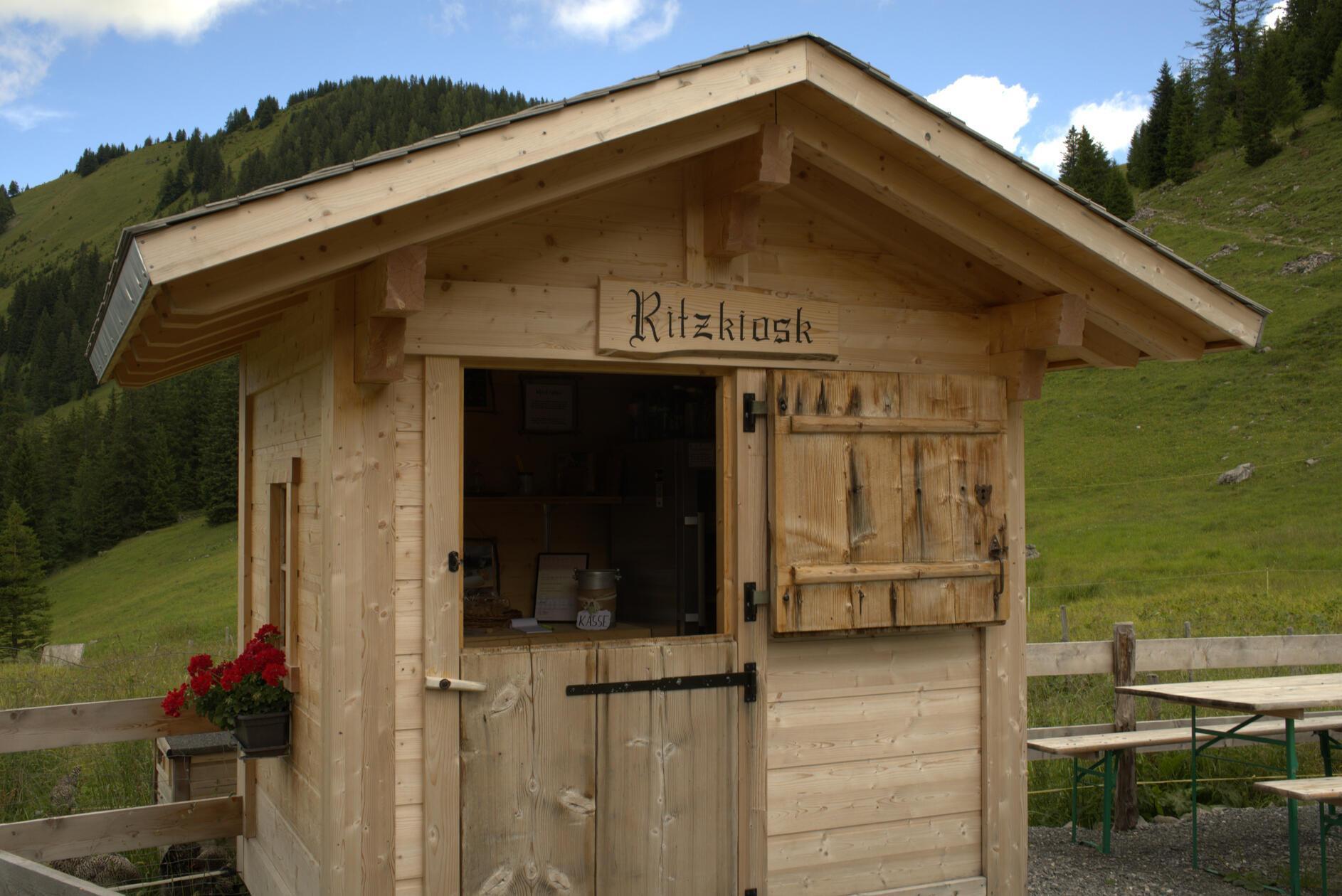 Der niedliche Kiosk neben der Alp Ritz enthält alle Produkte, die die Wirtschaft hergibt: Hobelkäse und Alpkäse, den sogenannen „Mutschli“-Käse, der vier Monate lang gereift ist, sowie Ziegenkäse und frische Milch. Außerdem gibt es Rindersalami und eine Auswahl an heißen und kalten Getränken – alles in Selbstbedienung