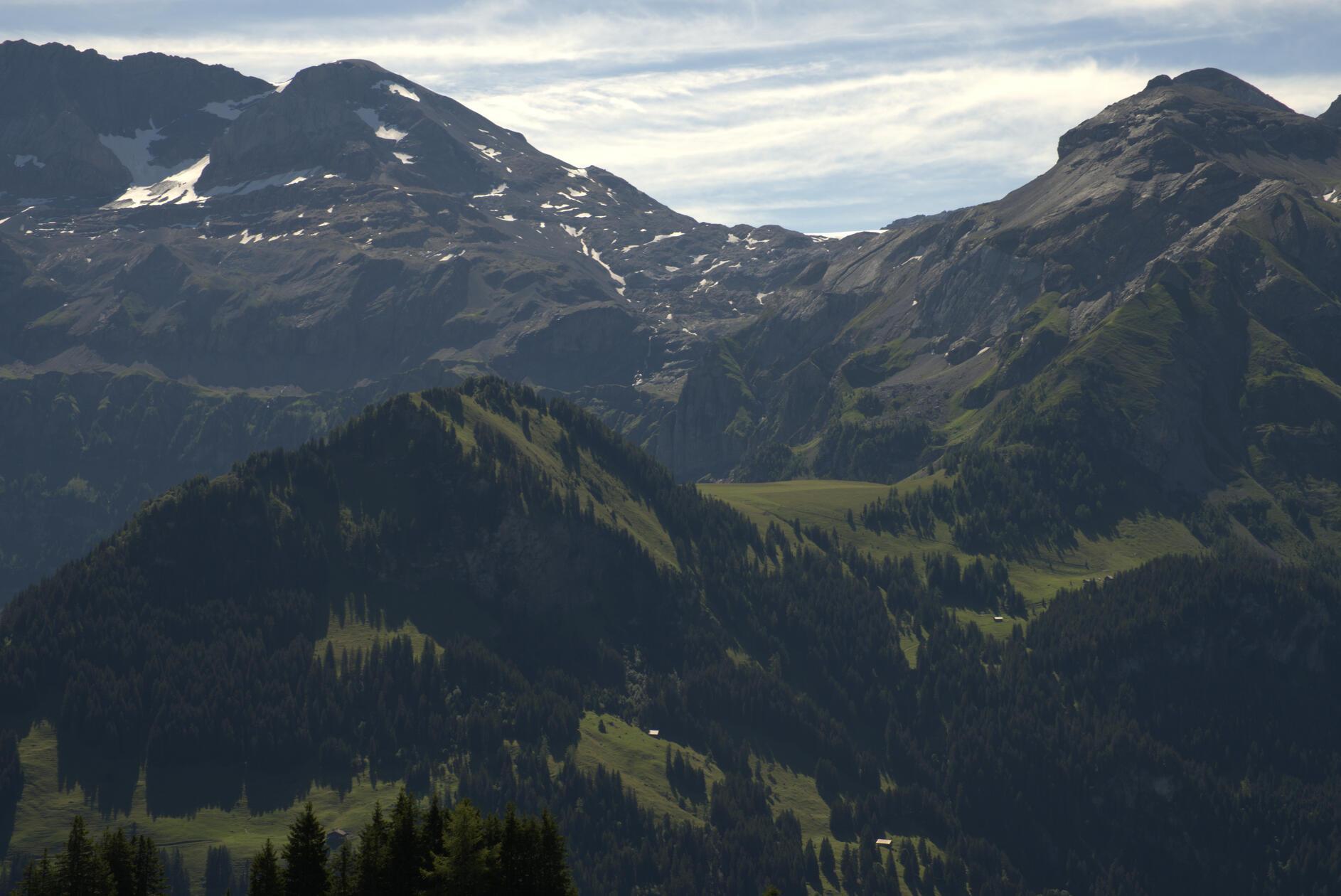Der Blick aus der Vogelperspektive auf die Langermatte (mittig im Bild): eine weite und recht flach verlaufende Wiesenfläche auf 1850 Metern Höhe. Rechts davon und unterhalb sieht man das Dach der Alp Ritz.