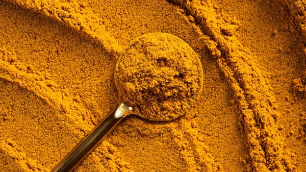 A vibrant close-up of golden curry powder, showcas
