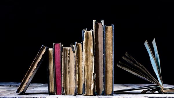 Old destroyed books on a wooden table. Reading roo