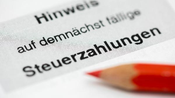 Ein Rotstift liegt auf einem Steuerbescheid vom Fi
