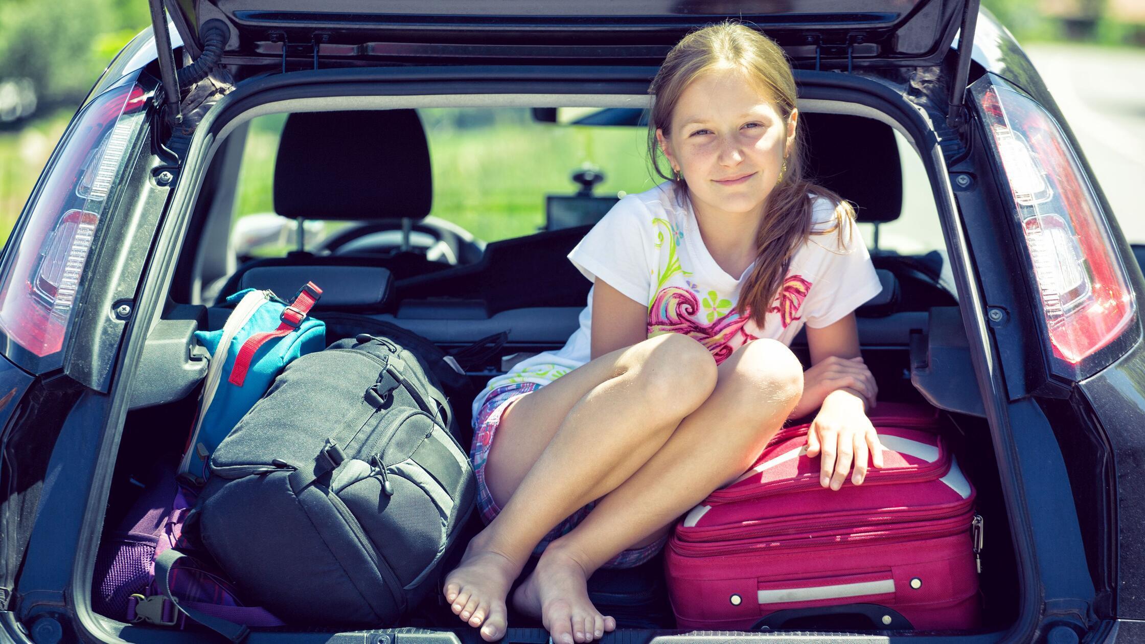 young  girl portrait at the car trunk