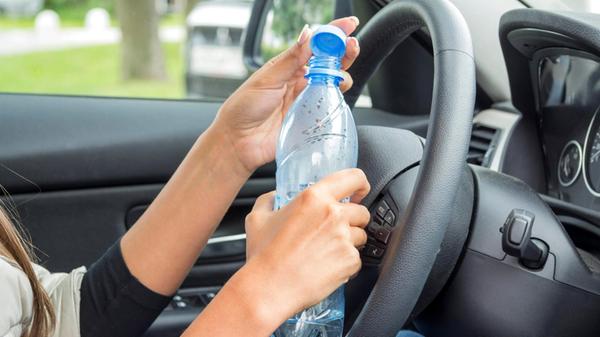 Girl in the car with a bottle of clean drinking wa
