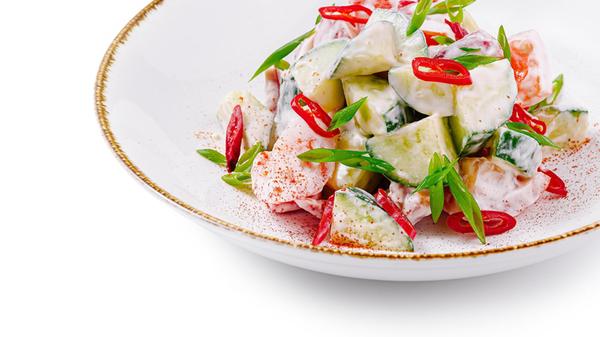 Frischer Salat mit Gurke und Tomate, gewürzt mit r