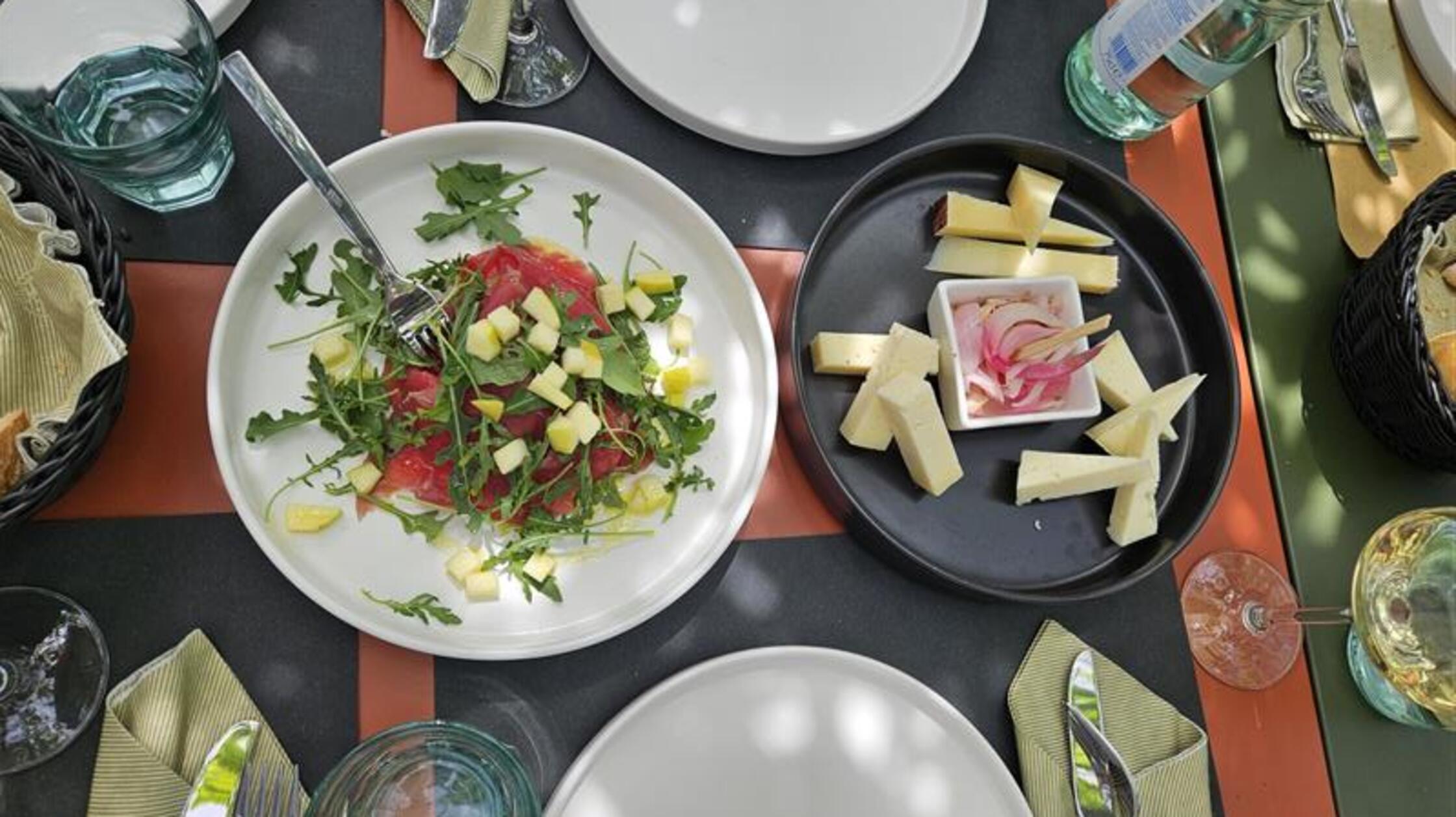 Carpaccio mit frischen Äpfeln und Hartkäse mit eingelegten Zwiebeln - im Ristorante All’Ersilia können Gäste unter grünen Dächern von Vorspeisenplatten probieren und teilen.