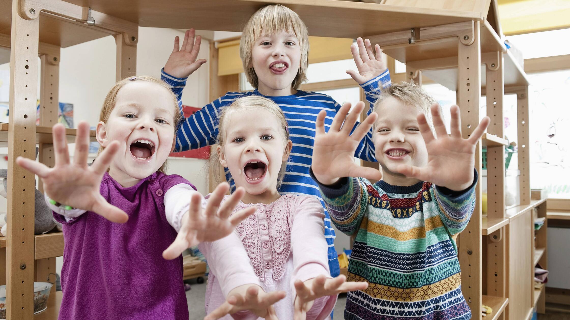 Four children with outstretched arms screaming mit