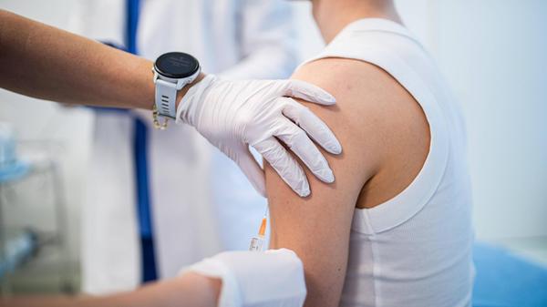 Teenage boy receiving vaccination during routine h