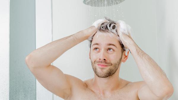 Mann wäscht sich unter der Dusche die Haare4371.jp