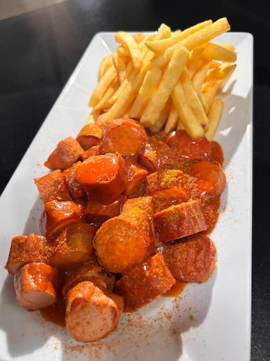 Platz 7: In Nürnberg-Giblitzhof verkauft die Metzgerei Kumpf Fleischwaren und Wurstspezialitäten aus der Region. Der Familienbetrieb bietet neben rohem Fleisch einen wechselnden Mittagstisch an. Im Metzgerei-Bistro in der Erlenstraße 11 ist vor allem die XL-Currywurst bei unseren Userinnen und Usern beliebt. Das Gericht serviert die Familie dort mit Pommes, auch eine "normale" Portion ist dort bestellbar. In unserem Voting schafft es die Wurst auf Platz sieben.