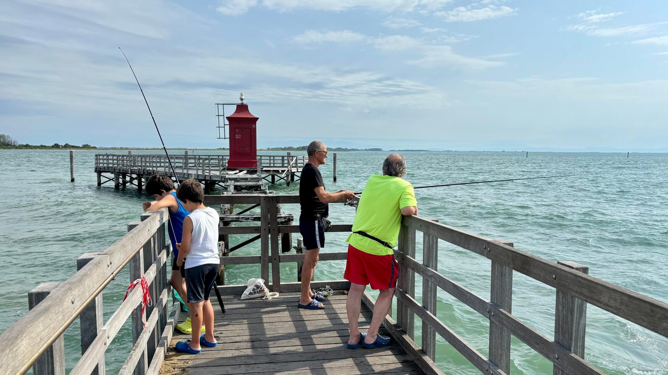 ... befindet sich ganz am Ende des Stegs ein knallroter Leuchtturm. Am Steg findet man oft auch einheimische Angler, die hier ihr Glück versuchen.