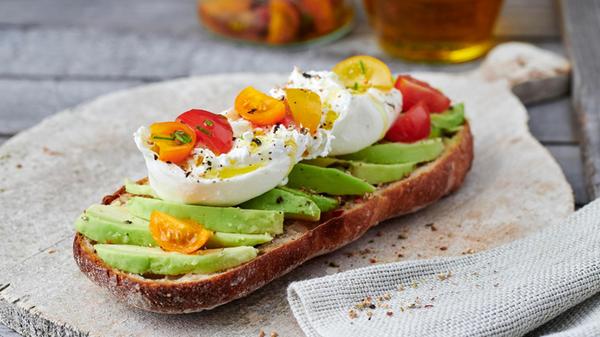 A baguette topped with avocado and burrata