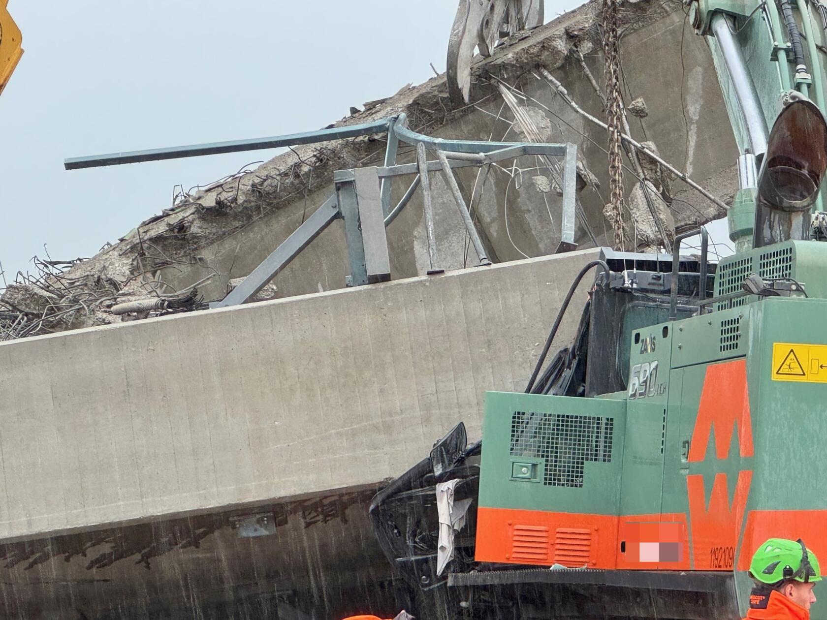 Zur Stunde versuchen die verbliebenen Bagger, den begrabenen Greifer unter dem Pfeiler herauszuziehen.