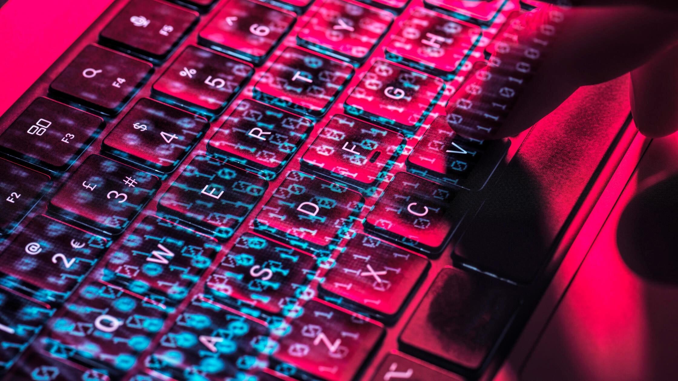 Close-up of a hand typing on a laptop keyboard wit