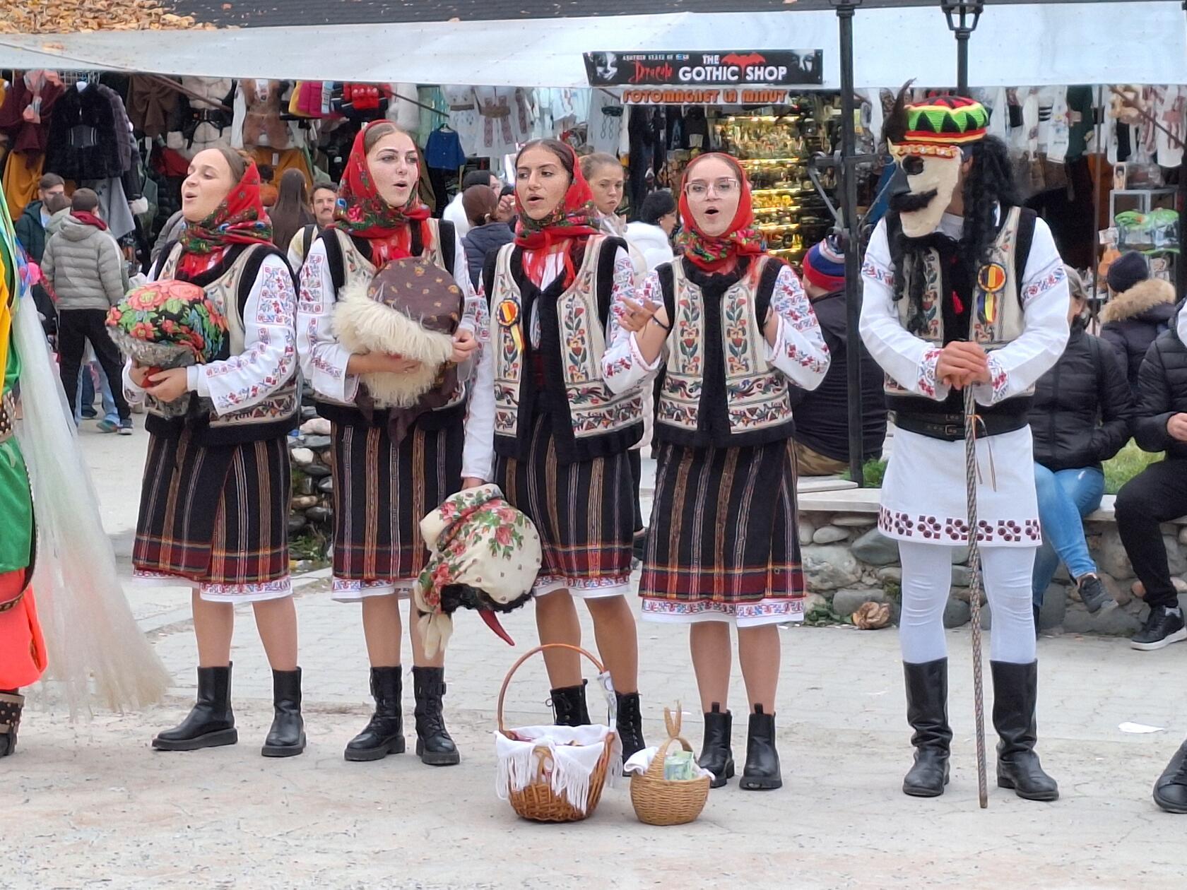 Die Sängerinnen tragen Tracht, die Männer Masken.
