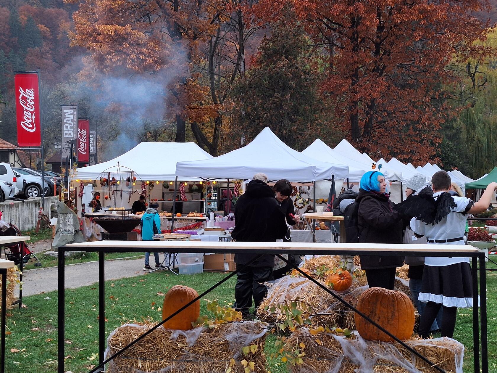 Blick auf einen Herbstmarkt in einem Park in Bran. Der Rauch stammt vom Grill.