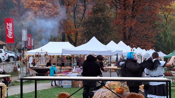 Blick auf einen Herbstmarkt in einem Park in Bran. Der Rauch stammt vom Grill.