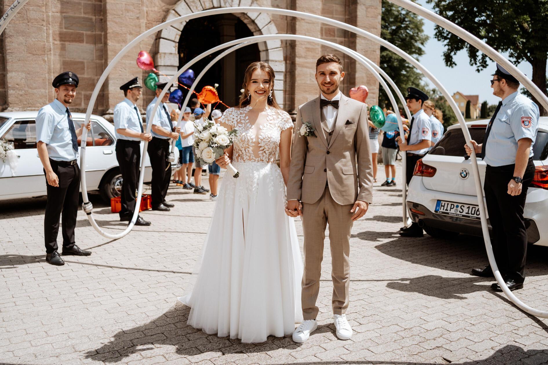 Genau ein Jahr nach der standesamtlichen Hochzeit führte der Weg der Eheleute Anja und Jonas Hackner in die Freystädter Wallfahrtskirche „Maria Hilf“, wo sie sich den kirchlichen Segen für ihren gemeinsamen Lebensweg erbaten. Vor der Kirche bildeten die Mitglieder der Freystädter Wehr, der der Bräutigam angehört, und Freunde ein Spalier. Eine Delegation von Mädels und Jungs von der Grundschule Ellingen, in der die Braut Lehrerin ist, wünschten dem Paar mit einem Lied alles Gute. Im Anschluss fuhren sich die 25-jährige Grundschullehrerin Anja, geborene Gilch, aus dem Hilpoltsteiner Ortsteil Pierheim und der 28-jährige selbständige Foto- und Videograph - er führt die Firma „Kunstwerk Media“ in Freystadt - zur Hochzeitsfeier im Spitalstadl.