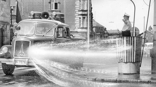 Wie ein Geschenk des Himmels betrachtete der Verkehrspolizist am Plärrer den Polizei-Wasserwerfer, der im Juli 1957 bei Temperaturen bis zu 38 Grad im Schatten eine erfrischende Dusche in seine Richtung schickte. Um den glühend heißen Asphalt etwas abzukühlen, drehte der Wasserwerfer der Polizei im Abstand von einer halben Stunde Runden um die Verkehrskanzel des schwitzenden Kollegen, bespritzte die dampfende Straße - und nebenbei auch ihn selbst ein wenig - mit wohltuend kühlem Nass.