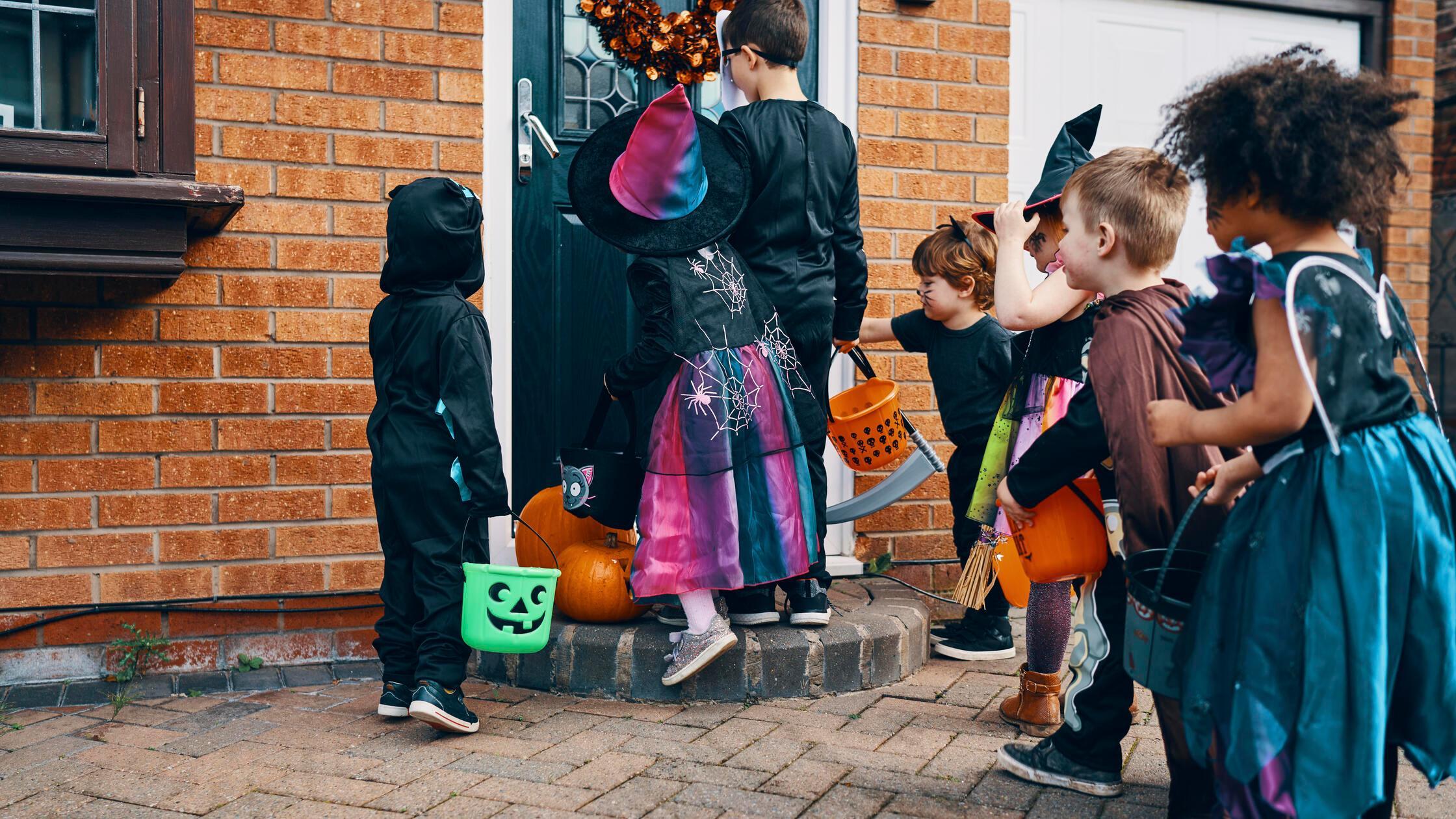 Dressed up children in front of a door on Hallowee